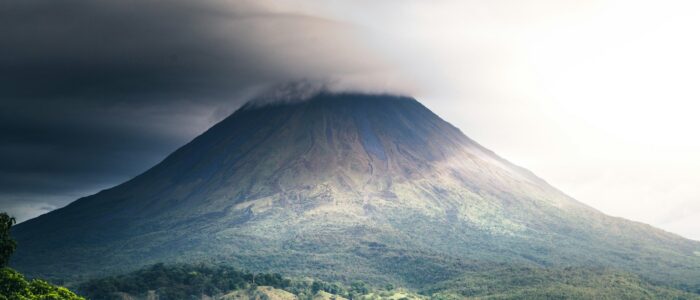 a very tall mountain with a very cloudy sky above it