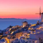 Santorini sunset with illuminated white buildings