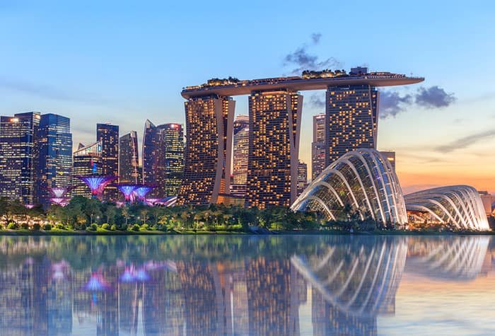 City skyline at sunset with water reflection.