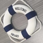 Welcome aboard lifebuoy on a wooden surface.